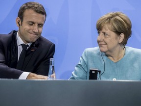 France's President Emmanuel Macron, left, and German Chancellor Angela Merkel, right, attend a press conference after a pre-G20 meeting in Berlin, Germany, Thursday, June 29, 2017