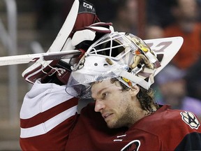 In this March 22, 2016 file photo, Mike Smith adjusts his mask during a game against the Edmonton Oilers.