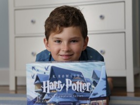 Theo Galkin, 8, poses for a picture with his set of Harry Potter books at his home in South Orange, N.J., Wednesday, June 28, 2017. As the 20th anniversary of the initial publishing of the first Harry Potter book is celebrated this week, another generation is being introduced to Harry, Hogwarts and all the rest of the magical world created by author J.K. Rowling. (AP Photo/Seth Wenig)