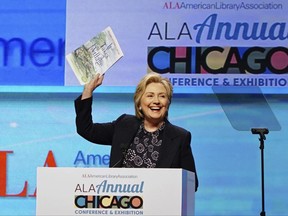 Hillary Clinton holds up an illustrated children's version of her book, 'It Takes a Village', as she speaks at the American Library Association (ALA) Annual Conference and Exhibition, Tuesday, June 27, 2017, in Chicago. (AP Photo/Teresa Crawford)