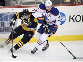 In this Nov. 8, 2016 file photo, Pittsburgh Penguins forward Sidney Crosby (left) and Edmonton Oilers forward Connor McDavid fight for the puck.