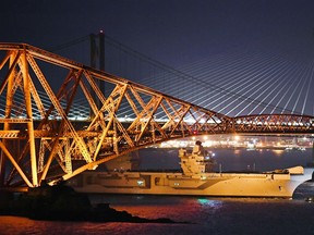 The new Royal Navy aircraft carrier HMS Queen Elizabeth, is pulled by tug boats underneath the Forth Rail Bridge as departs for sea trials in the North Sea on June 26, 2017 in South Queensferry, Scotland. HMS Queen Elizabeth is the largest and most powerful surface warship ever built for the Royal Navy
