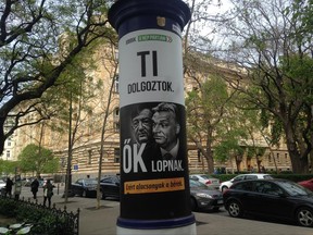 This April 12, 2017 photo shows a political billboard of the far-right Jobbik Party in Budapest Hungary that  reads: "Jobbik: On the people's side. You work, they steal - that is why salaries are low." The poster shows Prime Minister Viktor Orban, right, and Lorinc Meszaros, one of Hungary's richest people who has attributed his wealth in part to his friendship with Orban.  Hungarian government lawmakers passed legislation on Friday which the opposition claims will limit their billboard campaigns. (AP Photo/Pablo Gorondi)