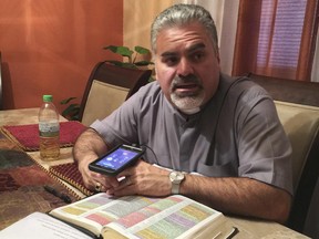 In this Friday, June 23, 2017 photo, Pastor Julio Barquero, a lay minister in the Disciples of Christ, holds a conference call bible study and prayer session with attendees to afraid to go to church in Houston. Many of the callers are undocumented immigrants. (AP Photo/ John L. Mone)