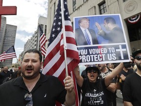 Iraqis and supporters rally outside the Theodore Levin United States Courthouse, Wednesday, June 21, 2017 in Detroit. A hearing began on a lawsuit that seeks to stop the government from deporting more than 100 Iraqi nationals who were recently rounded up. The American Civil Liberties Union filed the lawsuit in federal court in Detroit against U.S. Immigration and Customs Enforcement seeking a temporary stay of deportations. The ACLU says possible deportations aren't expected at least until after the request is heard. (AP Photo/Carlos Osorio)