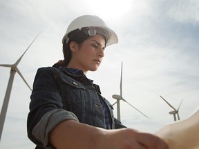 Female engineer at wind farm with plans