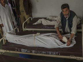A Kashmiri man covers the body of an Indian tourist at a hospital near Gulmarg, northwest of Srinagar, Indian controlled Kashmir, Sunday, June 25, 2017. Four Indian tourists and three local residents died on Sunday when a cable car came crashing down from a height of at least 30 meters (100 feet) in the tourist resort of Gulmarg in the Indian portion of Kashmir. (AP Photo/Dar Yasin)
