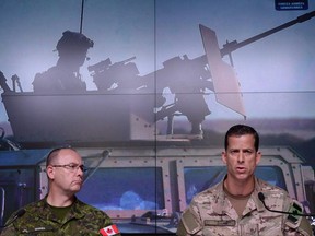 Lieutenant-General Stephen Bowes, left, and Brigadier-General Peter Dawe speak as the Canadian Armed Forces provides an update on Operation IMPACT in the Middle East during a press conference at National Defence headquarters in Ottawa on Thursday, Oct. 6, 2016. Dawe, the deputy commander of Canadian special forces, says the sniper who shattered the record for the longest confirmed kill also saved lives THE CANADIAN PRESS/Sean Kilpatrick