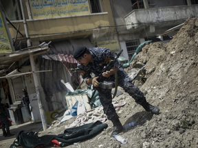 An Iraqi Federal Policeman runs away after he fired shots at an ISIL group positioned on the western side of Mosul, Iraq.
