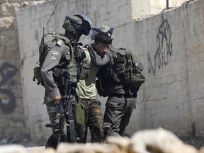 Israeli border police arrest a Palestinian during clashes in the West Bank  village of Deir Abu Mash'al near Ramallah, Saturday, June 17, 2017.