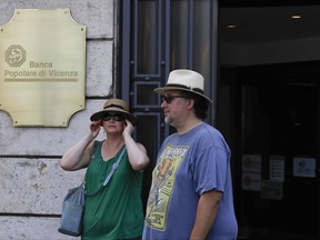 A couple leaves a Banca Popolare di Vicenza branch in Milan, Italy, Monday, June 26, 2017. Premier Paolo Gentiloni defended the swift action by the government as vital for ensuring Italy's slow economic recovery isn't derailed by a "disorderly" failure of Veneto Banca and Banca Popolare di Vicenza. The two banks are based in the northeast Veneto region, one of Italy's most economically productive. They serve many of the small and medium-sized businesses that are the backbone of the nation's economy. (AP Photo/Luca Bruno)
