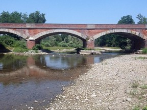 Scarce water passes under a bridge on the Po river in Staffarda, Northern Italy, Friday, June 23, 2017. Italy's farm lobby is warning that agricultural production is plummeting nationwide because of prolonged heat and dry weather -- and authorities are now rationing water and declaring a state of emergency in some areas. (Rosso/ANSA via AP)