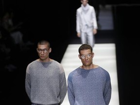 Models wear creations of the Giorgio Armani men's Spring-Summer 2018 collection, part of the Milan Fashion Week, unveiled in Milan, Italy, Monday, June 19, 2017. (AP Photo/Antonio Calanni)