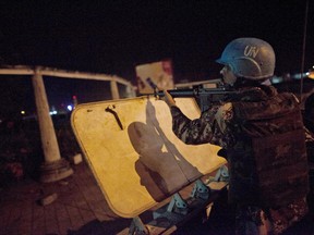 FILE - In this Monday, April 4, 2011, file photo, a U.N. peacekeeper from Jordan provides security at night on the streets of Abidjan, Ivory Coast. The U.N. peacekeeping mission in Ivory Coast is coming to an end Friday, June 30, 2017, 13 years after forces intervened to implement a peace agreement that left the war-wracked economic giant split into two pieces. (AP Photo/Jane Hahn, File)