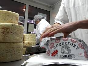 FILE - In this Jan. 22, 2009, file photo, French family company Carles employees work at Carles Roquefort cheese factory in Roquefort, southwestern France. Japan and the European Union are hoping to reach an economic partnership agreement within days, countering the backlash against free trade by U.S. President Donald Trump. Their trade and agriculture ministers are due to meet in Tokyo on Friday, June 30, 2017, trying to forge a deal before the Group of 20 industrial nations meets next week in Germany. Local reports said a main point of disagreement was Japan's up to 40 percent tariffs on imported cheese. (AP Photo/Bob Edme, File)