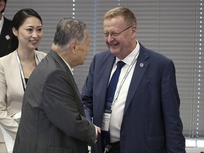 International Olympic Committee (IOC) Vice President John Coates, right, and Tokyo 2020 Olympics President Yoshiro Mori, center, shake hands prior to the IOC Coordination Commission opening plenary for the Olympic Games Tokyo 2020 in Tokyo Wednesday, June 28, 2017. (AP Photo/Eugene Hoshiko)