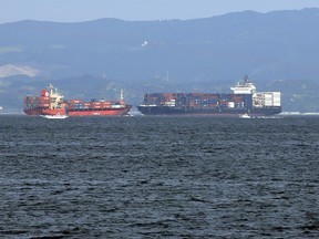In this Saturday, June 17, 2017, photo, the damaged Philippine-registered container ship ACX Crystal, right, cruises past another container ship off Yokosuka, south of Tokyo, after colliding with the USS Fitzgerald off Japan earlier in the day, that killed seven U.S. sailors. The site of a fatal collision between the two vessels off Japan's coast is notorious for congested sea traffic, particularly during the night when merchant ships are trying to reach Tokyo's port by daybreak. (AP Photo/Eugene Hoshiko)