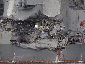 Damaged part of USS Fitzgerald is seen at the U.S. Naval base in Yokosuka, southwest of Tokyo Sunday, June 18, 2017.  Navy divers found a number of sailors' bodies Sunday aboard the stricken USS Fitzgerald that collided with a container ship Saturday in the busy sea off Japan. (AP Photo/Eugene Hoshiko)