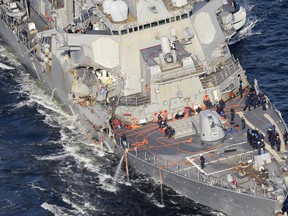 In this Saturday, Junes 17, 2017, photo, the damaged USS Fitzgerald is seen off Yokosuka, near Tokyo, Japan, after the Navy destroyer collided with a merchant ship.  The U.S. Navy says the bodies of sailors who went missing in the collision between the USS Fitzgerald and a container ship have been found aboard the stricken destroyer. (Hitoshi Takano/Kyodo News via AP, File)