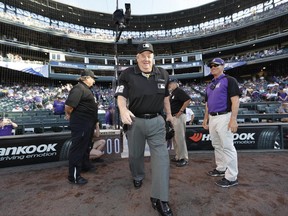 Crew chief Joe West steps on the track on his way to home plate to umpiring his 5,000th career game as the Colorado Rockies host the Arizona Diamondbacks in the first inning of a baseball game Tuesday, June 20, 2017, in Denver. (AP Photo/David Zalubowski)