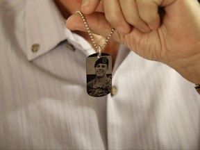 This June 17, 2017 photo shows a dog tag made in memorial of fallen U.S. Green Beret Kevin McEnroe worn by his father Brian in Amman, Jordan. Both Brian McEnroe and James Moriarty, fathers of two of the three American soldiers who were shot dead at a Jordanian military base, are attending the latest hearing in the trial here of the Jordanian serviceman accused of killing them. group. (AP Photo/Sam McNeil)