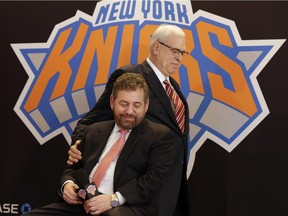FILE - In this March 18, 2014, file photo, New York Knicks new team president Phil Jackson puts his hand on team owner James Dolan, seated, during a news conference where Jackson was introduced, at New York's Madison Square Garden. The Knicks and Jackson parted ways Wednesday morning, June 28, 2017, ending a three-year tenure that saw plenty of tumult and not a single playoff appearance.(AP Photo/Richard Drew, File)