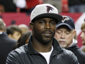FILE - In this Sunday, Jan. 1, 2017, file photo, former Atlanta Falcons quarterback Michael Vick stands on the sidelines before the first half of an NFL football game between the Falcons and the New Orleans Saints, in Atlanta. Life after football hits some NFL players harder than others. Michael Vick, Steve Smith and Justin Forsett are adjusting to their post-NFL careers nicely. (AP Photo/John Bazemore, File)