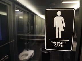 In this Thursday, May 12, 2016 file photo, signage is seen outside a restroom at the 21c Museum Hotel in Durham, N.C. In North Carolina, PayPal and Deutsche Bank cancelled expansion plans and other companies reconsidered their investments in the state after it implemented a measure regarding transgender people, similar to what Montana is considering placing on their 2018 fall ballot. (AP Photo/Gerry Broome, File)