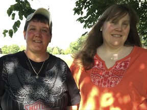 In this June 21, 2017 photo, Samantha "Sam" LaRochelle, left, stands with her wife, Audrey LaRochelle, at their home in Lopatcong Township, N.J., wearing the irreplaceable necklace that had been removed from her neck during an emergency visit to St. Luke's Hospital, in Phillipsburg on June 17, 2017. Staff at Covanta Energy Corp. in Oxford Township dug through a 15-ton pile of hospital waste to find it. (Kurt Bresswein/The Express-Times via AP)
