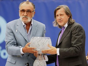 FILE - In this Sept. 27, 2009, file photo, former Romanian tennis stars Ion Tiriac, left, and Ilie Nastase pose with the trophy of the BCR Tennis Open tournament in Bucharest, Romania. Madrid Open organizer Ion Tiriac said Tuesday, June 20, 2017, he won't award any more trophies at his tournament because he is upset by the way his friend Ilie Nastase has been treated by the WTA. (AP Photo/Vadim Ghirda, File)