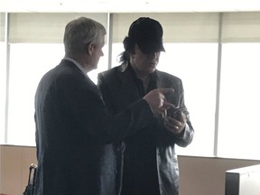 Former prime minister Stephen Harper chats with rocker Gene Simmons at Toronto Pearson Airport.