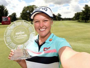 Brooke Henderson imitates a selfie with the Meijer LPGA Classic trophy on June 18.