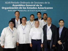 U.S. Deputy Secretary of State John Sullivan, center, poses for a group photo with Venezuelan opposition lawmakers and an opposition leader; Deputy Luis Florido, second left, front row; Deputy William Davila, second right; political coordinator of Voluntud Popular Carlos Vecchio, right; Deputy Carlos Lozano, left, back row; Deputy Franco Casella, second left, back row; Deputy Lester Toledo, third left, back row; Deputy Winston Flores, fourth left, back row, at the General Assembly of the Organization of American States in Cancun, Mexico, Tuesday, June 20, 2017.  Man on left, front row is unidentified. (AP Photo/Israel Leal)