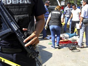 FILE - In this Jan. 4, 2017 file photo, Police and forensics secure the area where six people were killed, in Acapulco, Mexico. Government crime statistics show that the month of May was the country's bloodiest month in at least 20 years and homicides are up sharply in 2017 compared with the previous year. (AP Photo/Bernandino Hernandez, File)