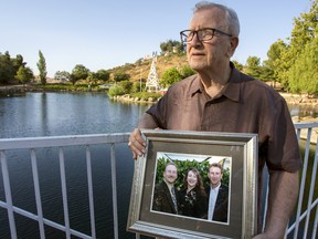 In this Friday, June 23, 2017 photo, Frank Kerrigan holds onto a photograph of his three children John, Carole, and Frank, near Wildomar, Calif.