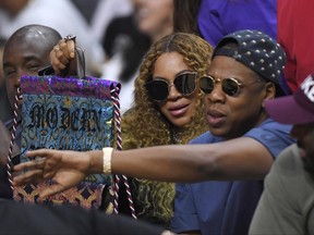 FILE - In this April 30, 2017, file photo, Beyonce and Jay Z watch during the first half in Game 7 of an NBA basketball first-round playoff series between the Los Angeles Clippers and the Utah Jazz in Los Angeles. Jay Z opened up about his relationship with Beyonce on his new album, "4:44," which was released June 30, 2017. (AP Photo/Mark J. Terrill, File)