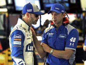 FILE - In this Feb. 12, 2016, file photo, Jimmie Johnson, left, talks with crew chief Chad Knaus in the garage during a practice session for a NASCAR auto race at Daytona International Speedway, in Daytona Beach, Fla. Seven-time championship winning crew chief Chad Knaus had his laptop stolen from a rental car in San Francisco, Wednesday, June 21, 2017, leaving him without the notes for Jimmie Johnson's NASCAR race this weekend at Sonoma .(AP Photo/Terry Renna, File)