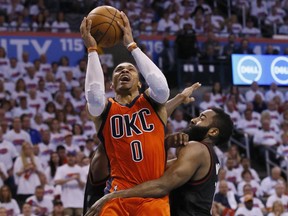 FILE - In this April 23, 2017 file photo, Oklahoma City Thunder guard Russell Westbrook (0) shoots between Houston Rockets guard Patrick Beverley, rear, and guard James Harden, right, in the fourth quarter of Game 4 of a first-round NBA basketball playoff series in Oklahoma City. Westbrook will join Houston's James Harden and San Antonio's Kawhi Leonard as finalists for the league's MVP award. The winner will be announced Monday, June 26, at the inaugural NBA Awards show. (AP Photo/Sue Ogrocki, File)