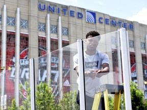Serell Williams works on a street hockey rink for the NHL Centennial Fan Arena outside the United Center as preparation for the NHL Draft continue, Thursday, June 22, 2017, in Chicago. The two day draft begins Friday. (AP Photo/G-Jun Yam)