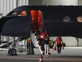 FILE- In this June 13, 2017, file photo, a crying woman exits a transport plane carrying Otto Warmbier, a 22-year-old University of Virginia undergraduate student who was imprisoned in North Korea in March 2016, as he is transferred from his transport aircraft to an ambulance at Lunken regional airport in Cincinnati. Warmbier, an American college student who was released by North Korea in a coma last week after almost a year and a half in captivity, died Monday, June 19, his family said. (AP Photo/John Minchillo, File)