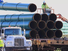 FILE - In this May 9, 2015, file photo, workers unload pipes in Worthing, S.D., for the Dakota Access oil pipeline that stretches from the Bakken oil fields in North Dakota to Illinois. A federal judge's order for more environmental review of the already-operating pipeline has several potential outcomes, all of which could spark even more wrangling in court. (AP Photo/Nati Harnik, File)