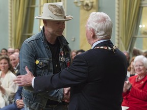 Governor General David Johnston shakes hands with Tragically Hip singer Gord Downie after investing him in the Order of Canada during a ceremony at Rideau Hall, Monday, June 19, 2017 in Ottawa. THE CANADIAN PRESS/Adrian Wyld