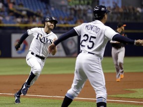 Tampa Bay Rays' Evan Longoria, left, races past third base coach Charlie Montoyo (25) to score on a triple by Logan Morrison off Baltimore Orioles starting pitcher Ubaldo Jimenez during the first inning of a baseball game Friday, June 23, 2017, in St. Petersburg, Fla. (AP Photo/Chris O'Meara)