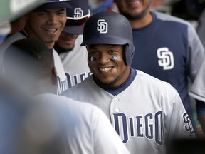 San Diego Padres' Erick Aybar smiles in the dugout after his home run off Chicago Cubs relief pitcher Brian Duensing during the sixth inning of a baseball game Wednesday, June 21, 2017, in Chicago. (AP Photo/Charles Rex Arbogast)