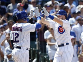 Chicago Cubs' Kyle Schwarber (12) and Ian Happ celebrate after they scored on Happ's home run during the fourth inning of a baseball game against the San Diego Padres Wednesday, June 21, 2017, in Chicago. (AP Photo/Charles Rex Arbogast)