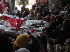 Pakistani women mourn beside the body of their relative, who was killed in the Sunday's fuel tanker fire incident at Ahmad Pur Sharqia near Bahawalpur, Pakistan, Monday, June 26, 2017. The Pakistani prime minister cut short a trip abroad to rush to the side of victims of the massive fuel tanker fire as authorities on Monday raised the death toll from the blaze to more than 155. (AP Photo/Iram Asim)