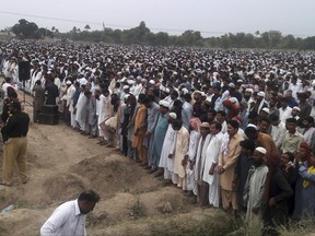 People offer funeral prayers for the victims of Sunday's fuel tanker fire incident in Bahawalpur, Pakistan, Tuesday, June 27, 2017. Thousands of mourners in Pakistan have attended the collective funeral for 130 victims of a massive fuel tanker fire on a central highway earlier this week. (AP Photo/Iram Asim)