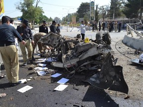 Pakistani police officers examine the site of an explosion in Quetta, Pakistan, Friday, June 23, 2017. A powerful bomb went off near the office of the provincial police chief in southwest Pakistan on Friday, causing casualties, police said. (AP Photo/Arshad Butt)