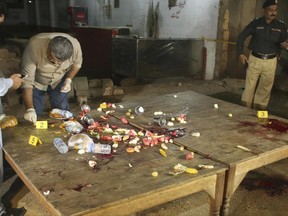 Pakistani investigators collect evidence from the site of firing incident in Karachi, Pakistan, Friday, June 23, 2017. Gunmen in the port city of Karachi attacked police officers at a roadside restaurant and killed four of them before fleeing, according to senior police officer Asif Ahmed. (AP Photo/Shakil Adil)