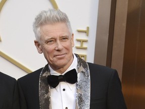 FILE- In this March 2, 2014, file photo, Adam Clayton of U2 arrives at the Oscars at the Dolby Theatre in Los Angeles. Clayton thanked his bandmates for their support during his treatment and recovery from alcohol abuse years ago, before joining them for a rollicking rendition of a few hits. Clayton received an award Monday, June 26, 2017, at a Manhattan theater from MusiCares, a foundation that helps musicians get treatment for addiction. (Photo by Jordan Strauss/Invision/AP, File)